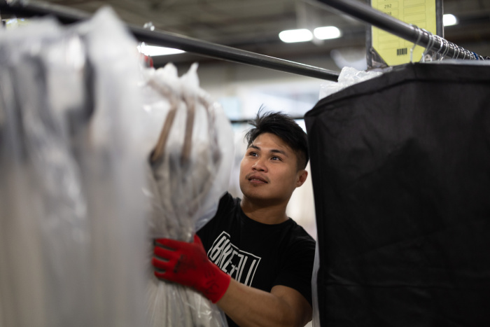 Bruidsmode Kleding wordt opgehangen aan de hangers door een medewerker van NE Distriservice